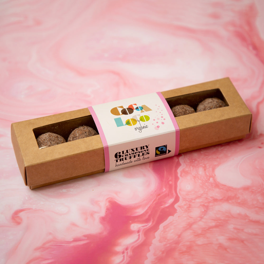 Cocoa Loco Organic Fairtrade milk chocolate champagne truffles box on a pink background