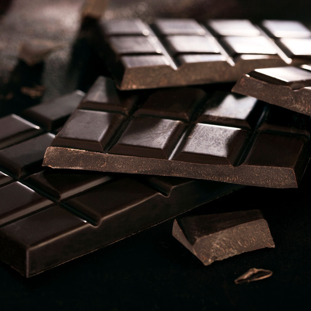 Close up on a a stack of Cocoa Loco fairtrade dark chocolate bars on a black background