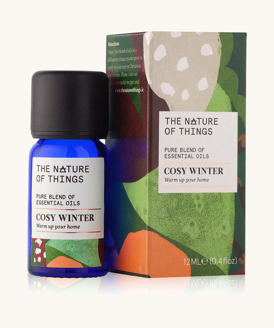 Cosy Winter Christmas pure essential oil blend in a blue glass bottle in front of a decorative festive cardboard box. 