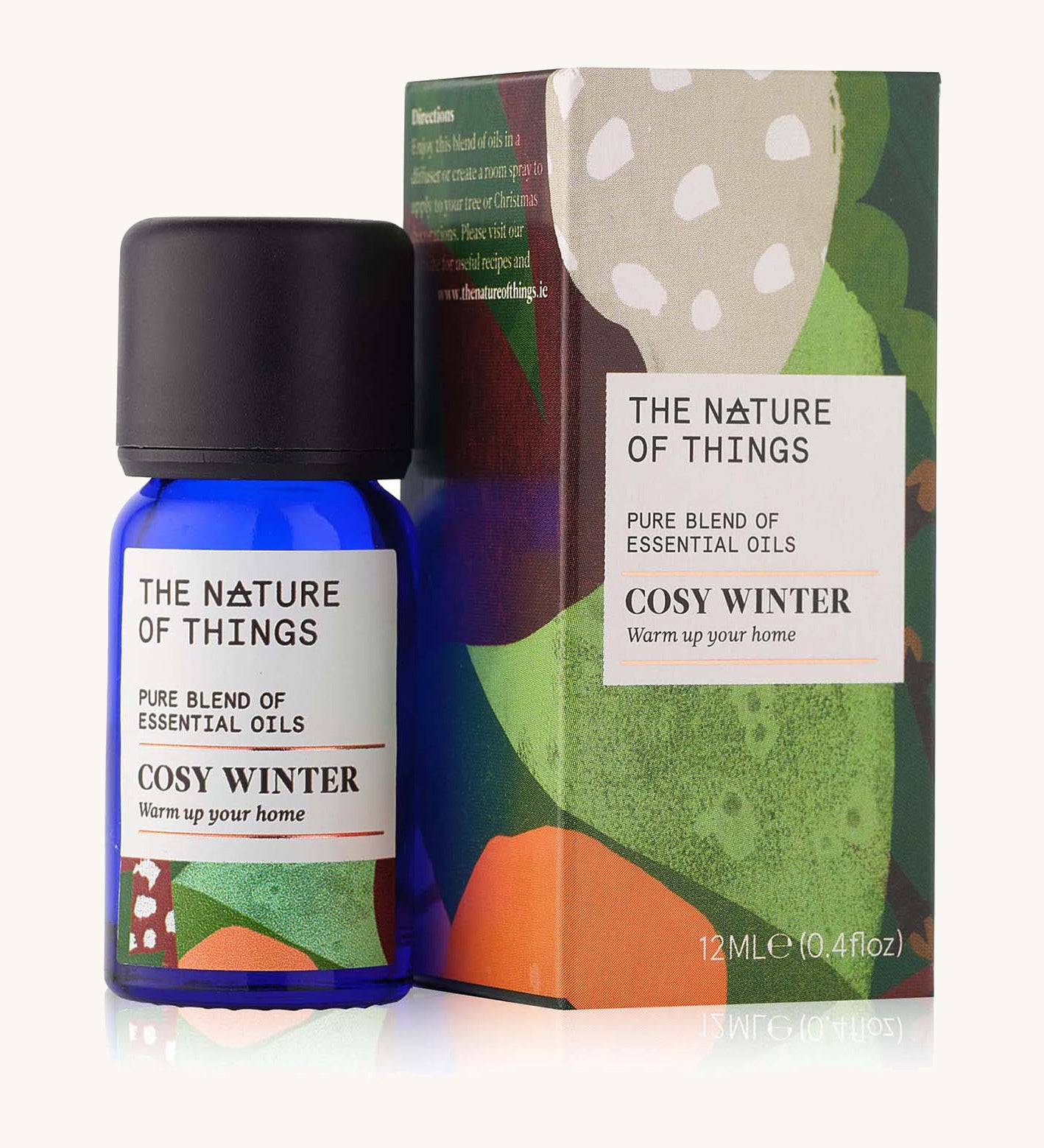 Cosy Winter Christmas pure essential oil blend in a blue glass bottle in front of a decorative festive cardboard box. 