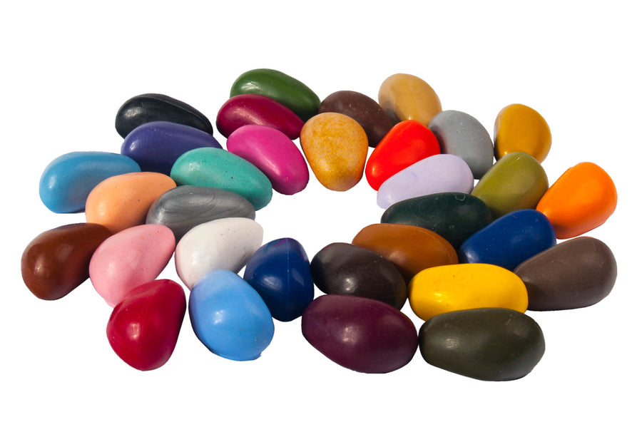 Kids coloured Crayon Rocks laid out in a circle on a white background