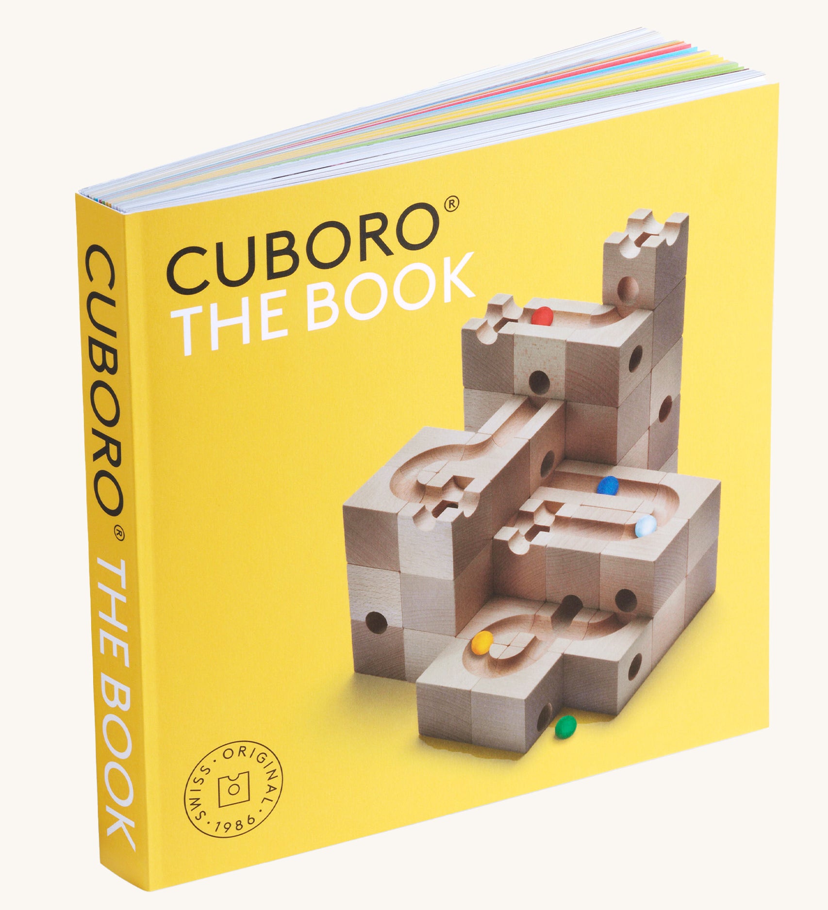 Cuboro marble run tips & tricks guide book stood up on a cream background showing the yellow cover