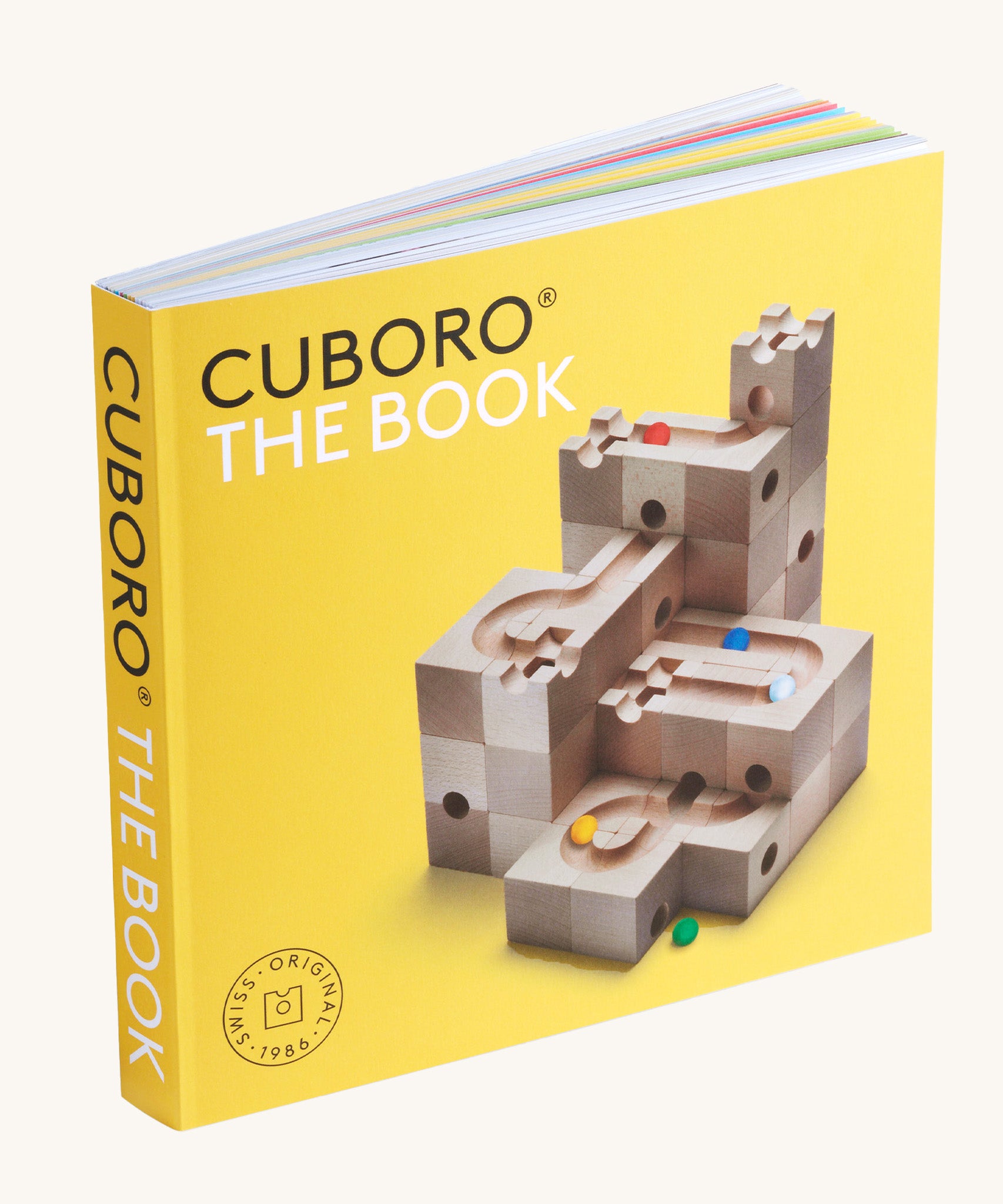 Cuboro marble run tips & tricks guide book stood up on a cream background showing the yellow cover