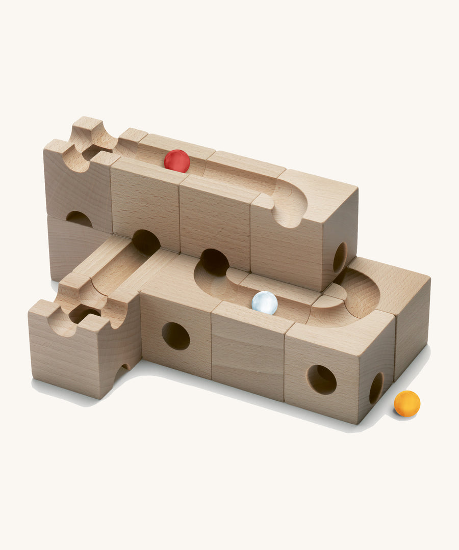 Cuboro children's pro wooden marble run toy blocks stacked on a cream background