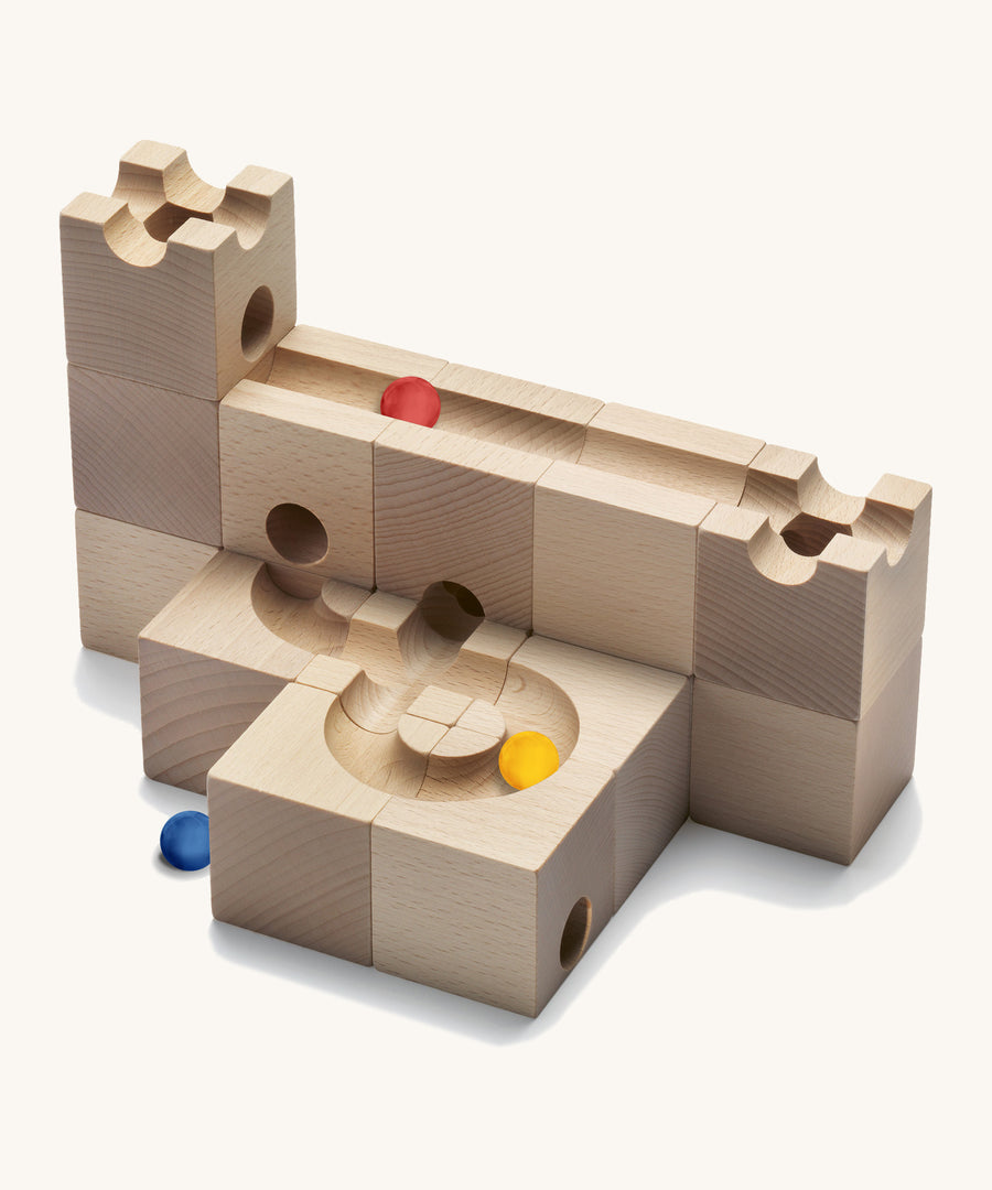 Cuboro Standard 16 piece wooden marble run building kit stacked on a cream background