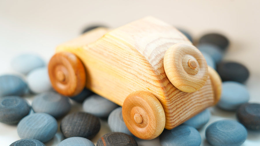 Close up of small Debresk wooden car on top of some grey Grapat counters