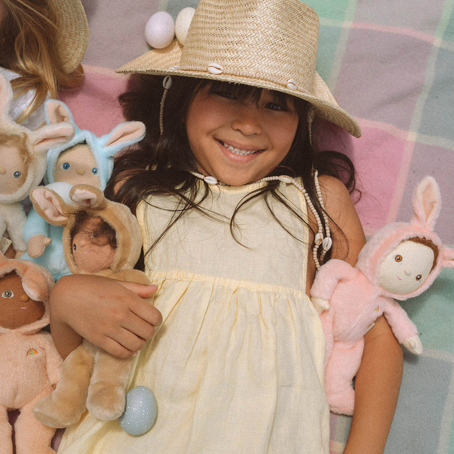 A child happily holding the Olli Ella Dinky Dinkum Doll Fluffles collection