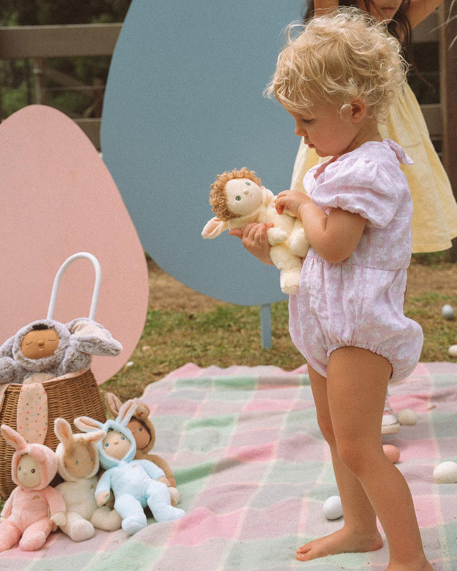 A child happily playing with the Olli Ella Dinky Dinkum Doll Fluffles collection