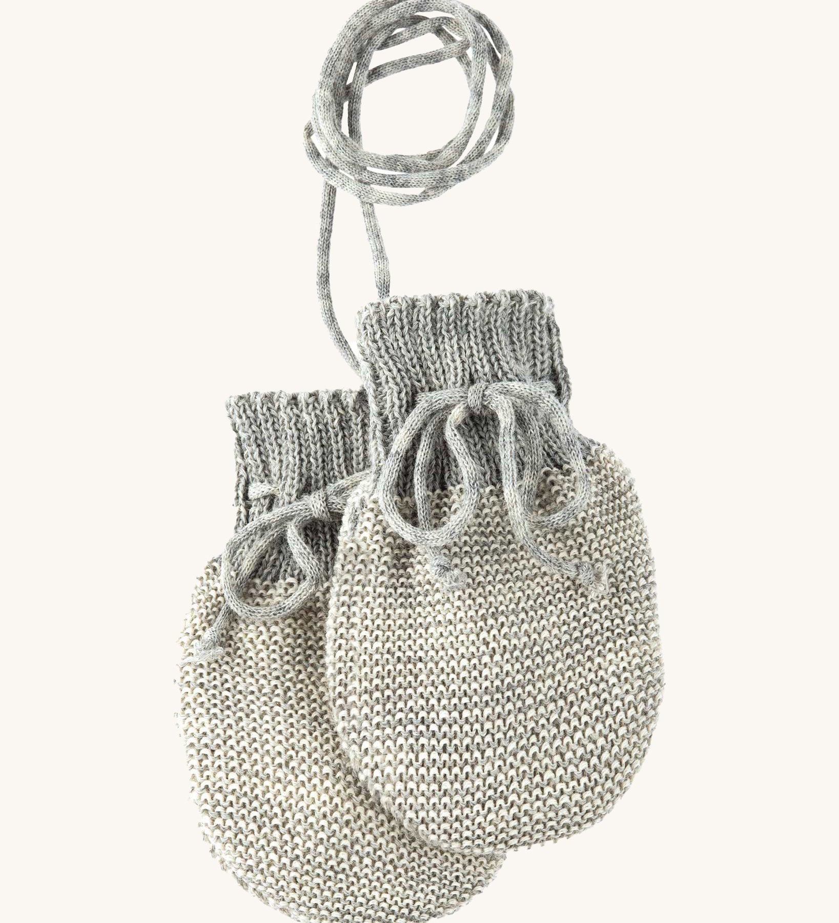 Disana organic merino wool baby mittens in grey and natural colour on a cream background.