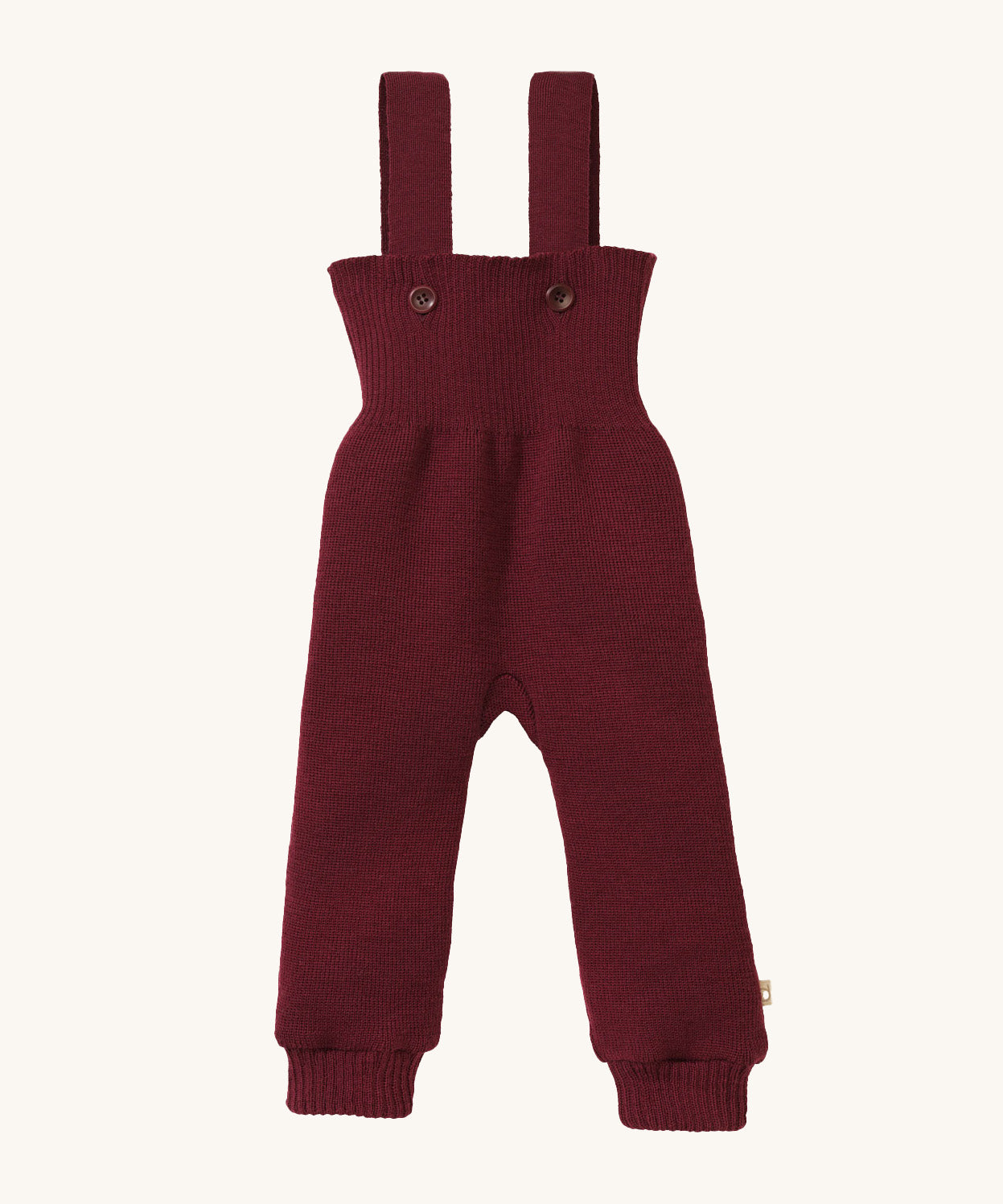 Disana organic merino wool dungarees in dark purple on a cream background.