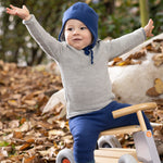 Disana organic merino wool melange jumper in a grey colour worn by a toddler playing on a toy bike