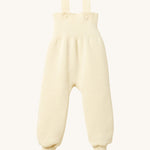 Disana organic merino wool dungarees in natural on a cream background.