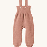 Disana organic merino wool dungarees in rose on a cream background.