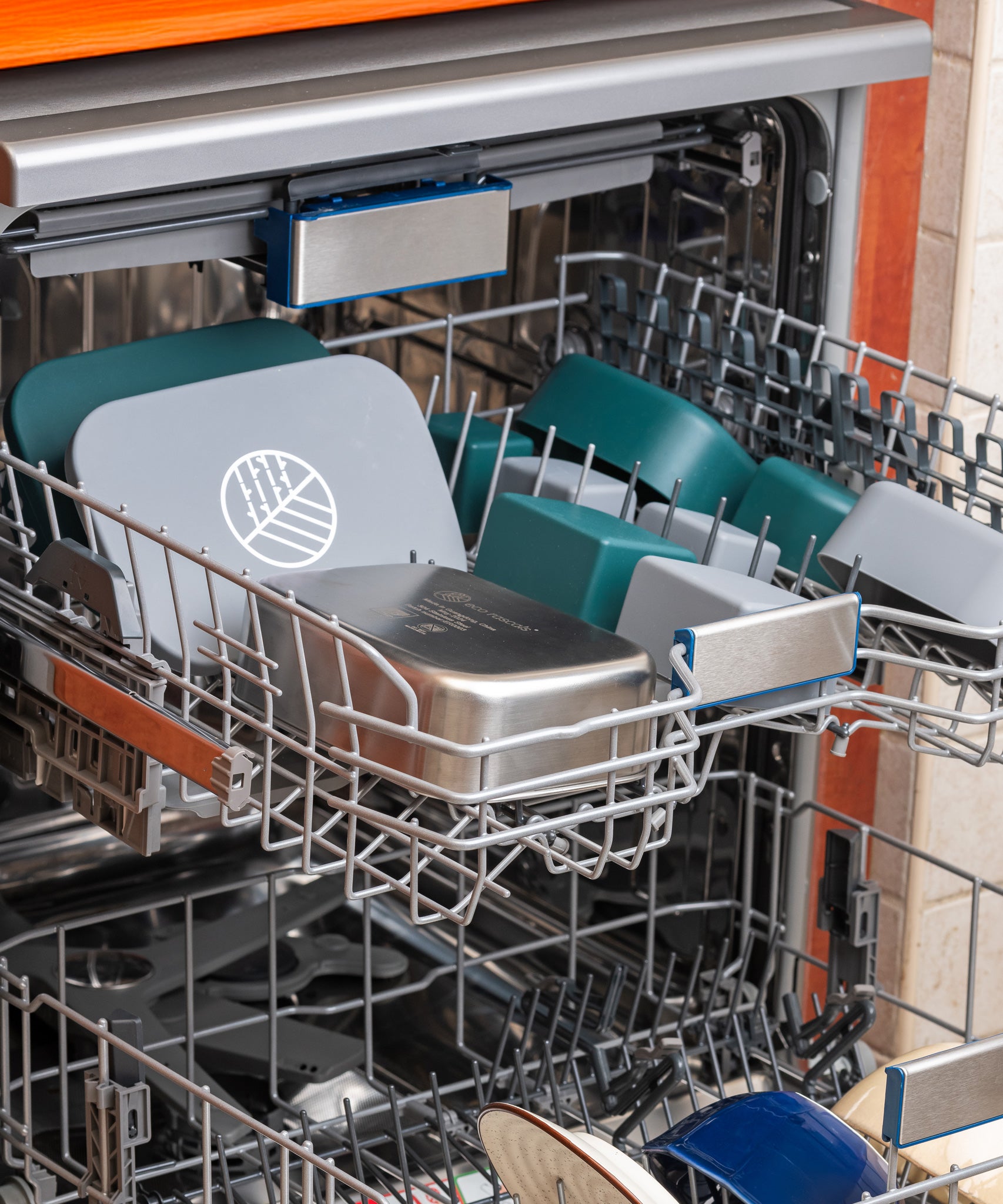 Two Eco Rascals Stainless Steel Lunch Boxes shown with all the pieces separated and placed on the top rack of a dishwasher. 