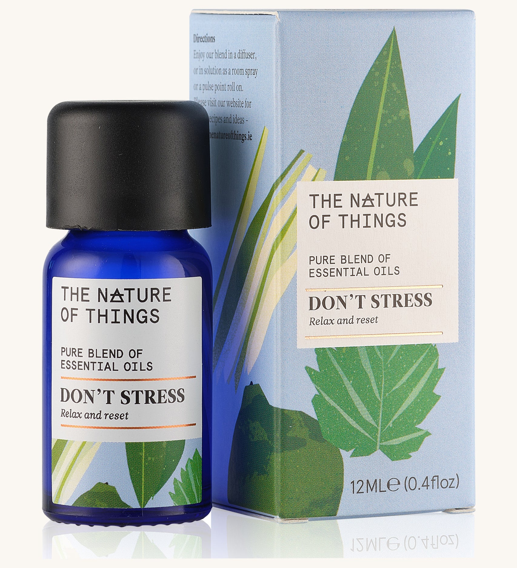 Don't Stress pure essential oil blend  in a blue glass bottle in front of a decorative blue cardboard box.