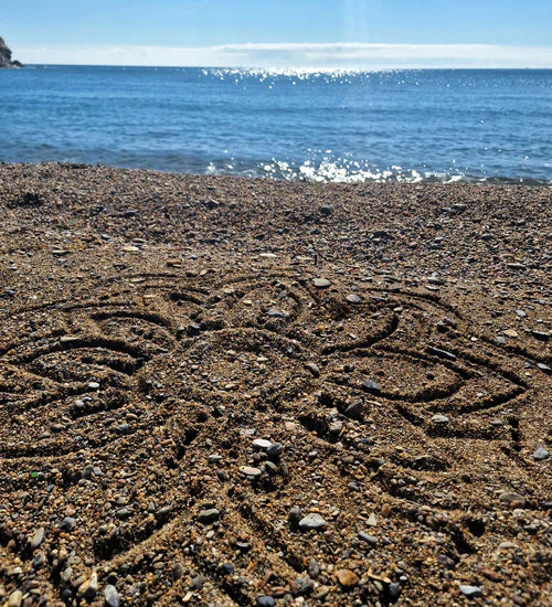 A mandala shape in the sand created using the bamboo tools for the Dr Zigs beach creativity set