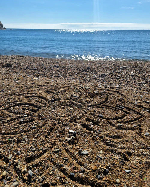 A mandala shape in the sand created using the bamboo tools for the Dr Zigs beach creativity set