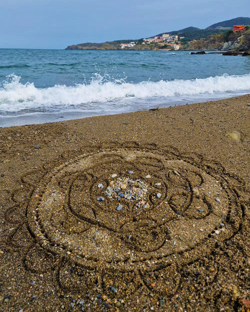 A mandala shape in the sand created using the bamboo tools for the Dr Zigs beach creativity set