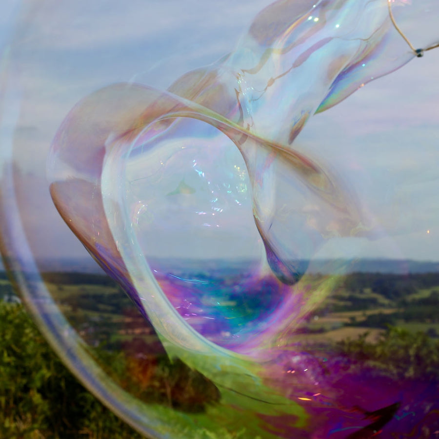 Close up of a Dr Zigs eco-friendly giant bubble flying over the countryside