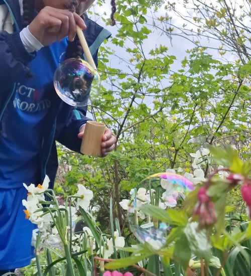 Child using the straw from the Dr Zigs bubble pollinator kit