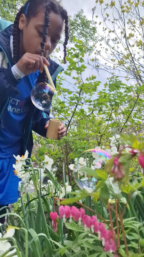 Child using the straw from the Dr Zigs bubble pollinator kit