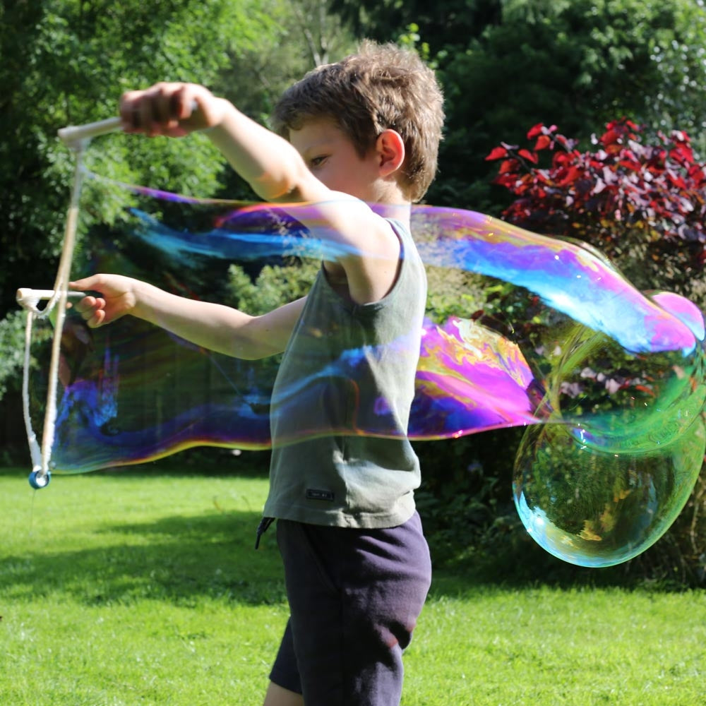 Boy making a giant bubble with the Dr Zigs jumbo bubble kit