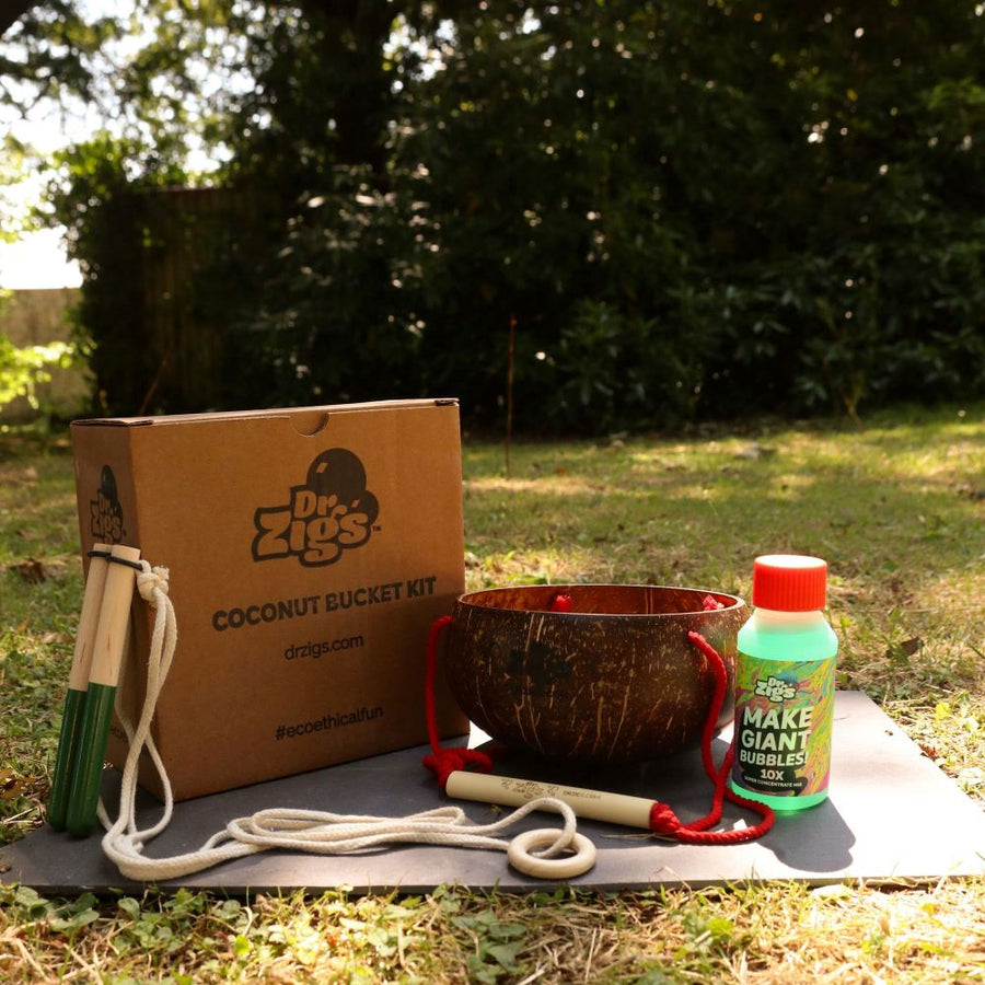 Dr Zigs childrens coconut bucket giant bubbles kit with its box in a garden with trees behind