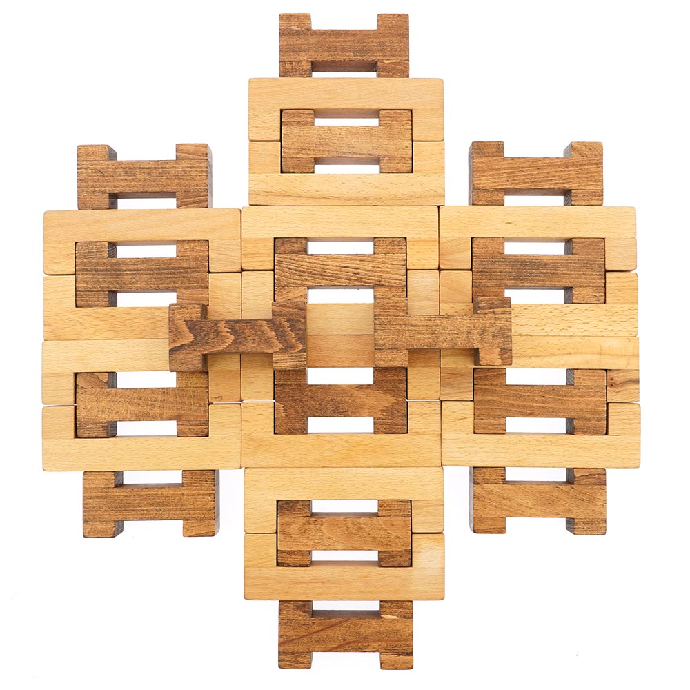 Drei Blätter hand carved 32-piece wooden block set laid out in a geometric shape on a white background