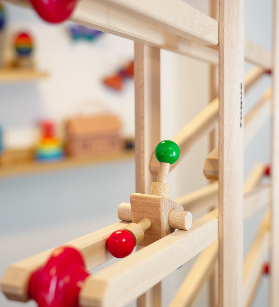 Close up of the Fagus click click marble run toy rolling down a Fagus wooden marble run set