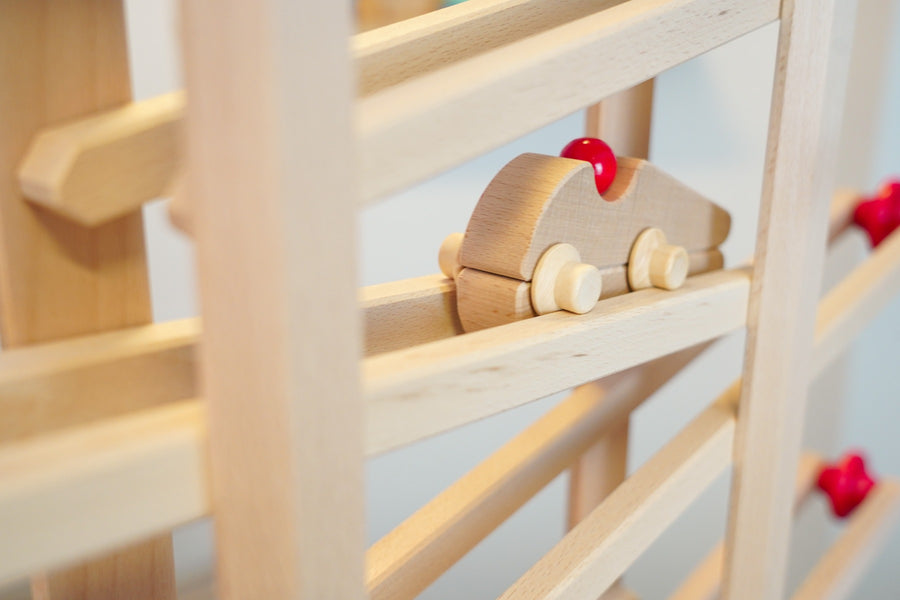 Close up of the Fagus Racer vehicle toy rolling down a Fagus wooden marble run set