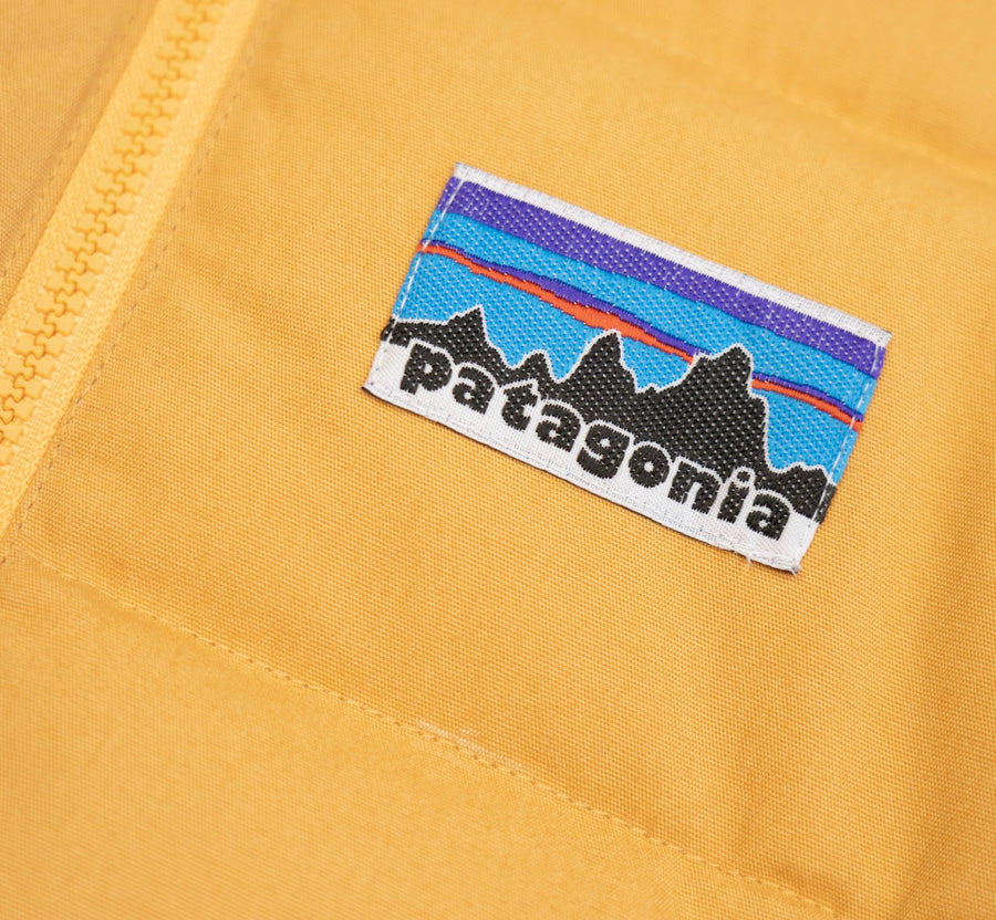 Patagonia Kids Cotton Quilted Down Jacket - Dried Mango. Logo detail close-up.