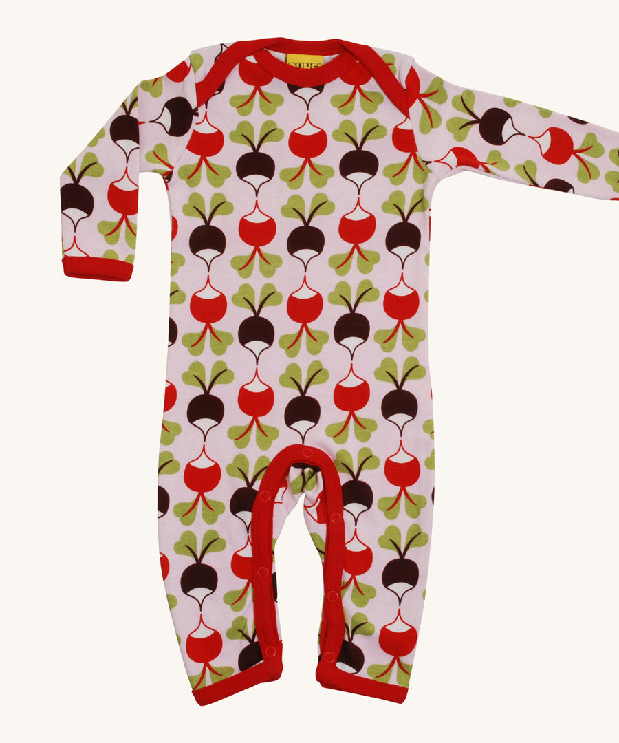 A light pink Duns babygrow with a red and brown radish design on a cream background