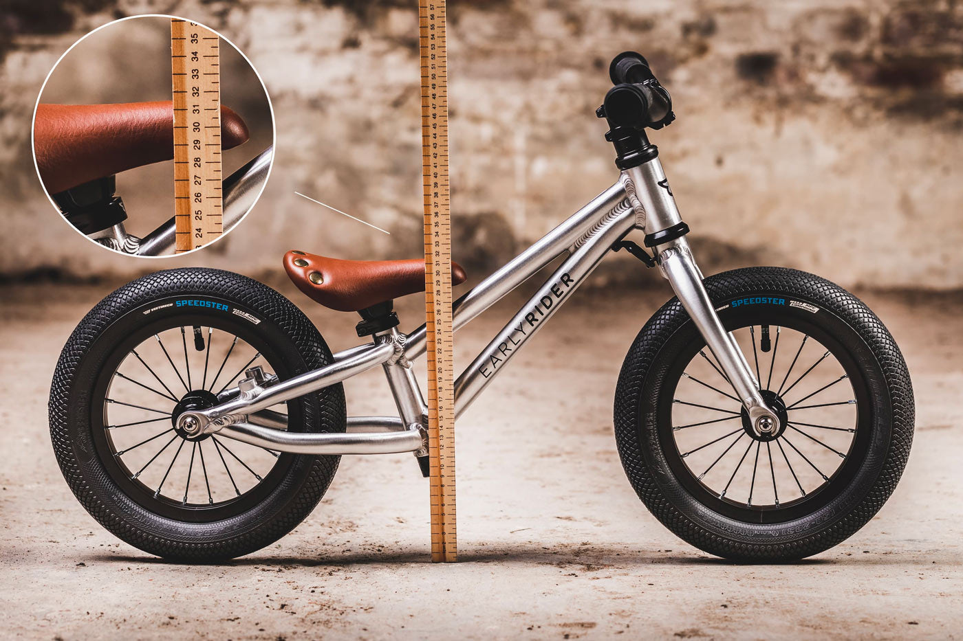 Close up of a child walking next to an Early rider charger balance bike