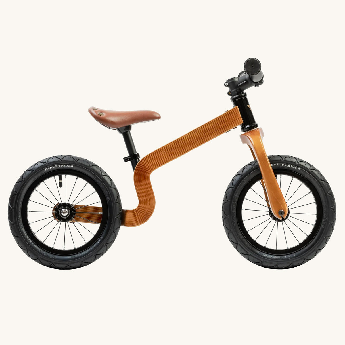 Side of the Early rider wooden 12 inch balance bike on a beige background