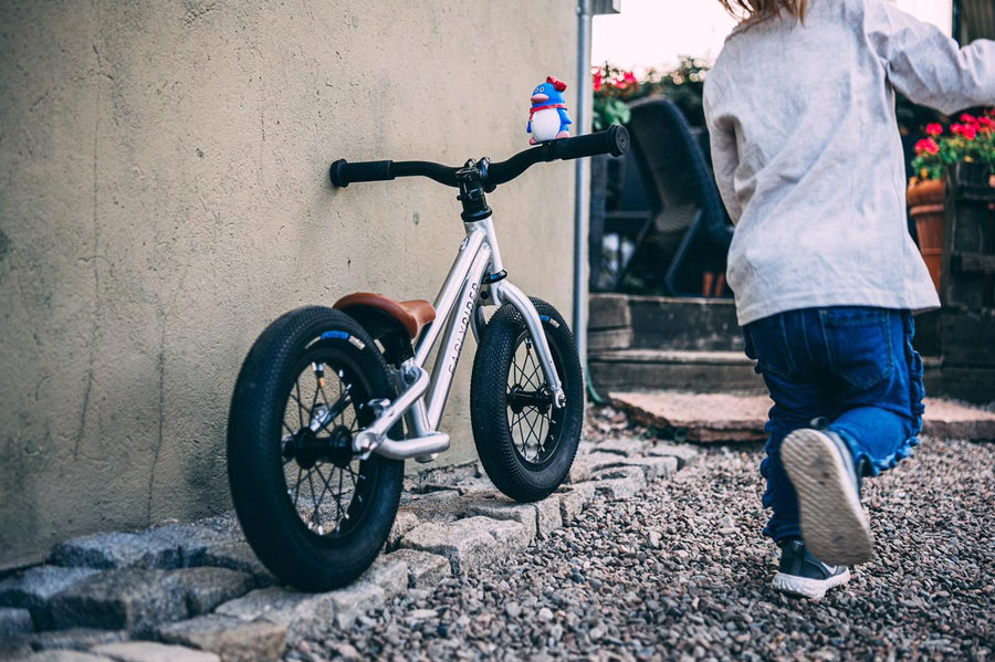 Young child riding the Early rider charger balance bike in some woods