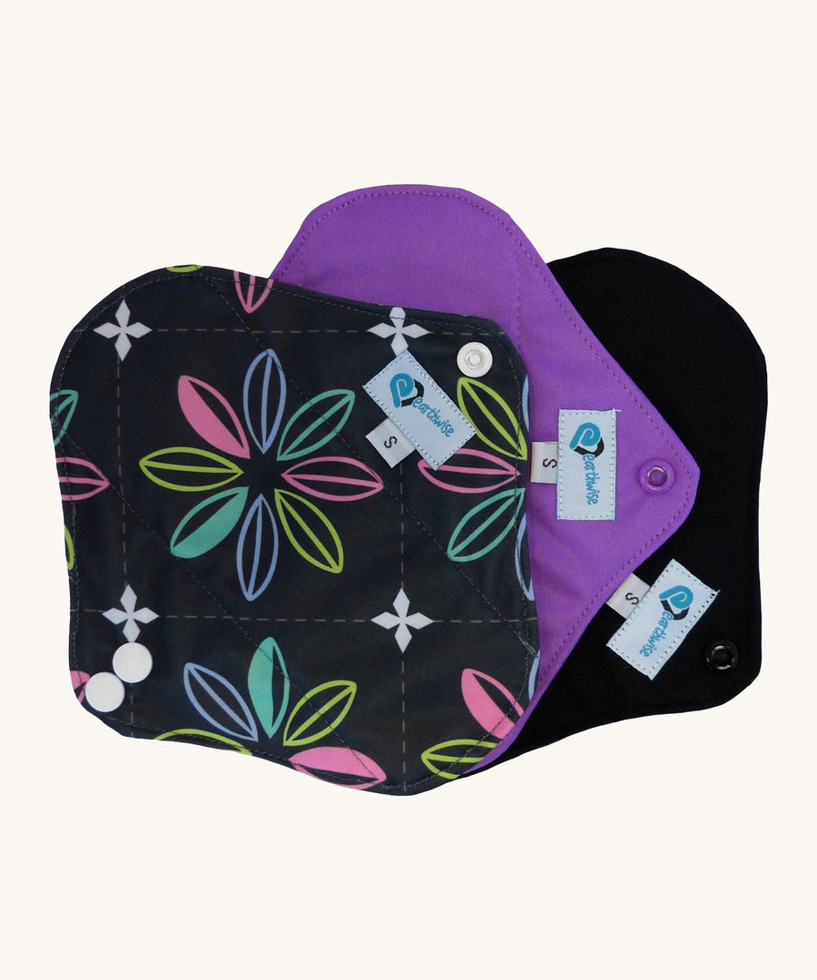 Three Earthwise Panty Liners in charcoal with flowers, purple and black.