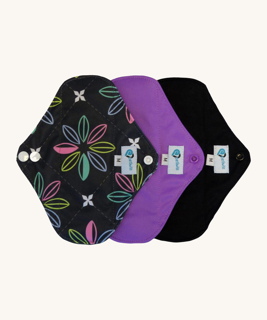 Three Earthwise reusable pads in charcoal with flowers, purple and black.