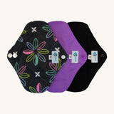 Three Earthwise reusable pads in charcoal with flowers, purple and black.