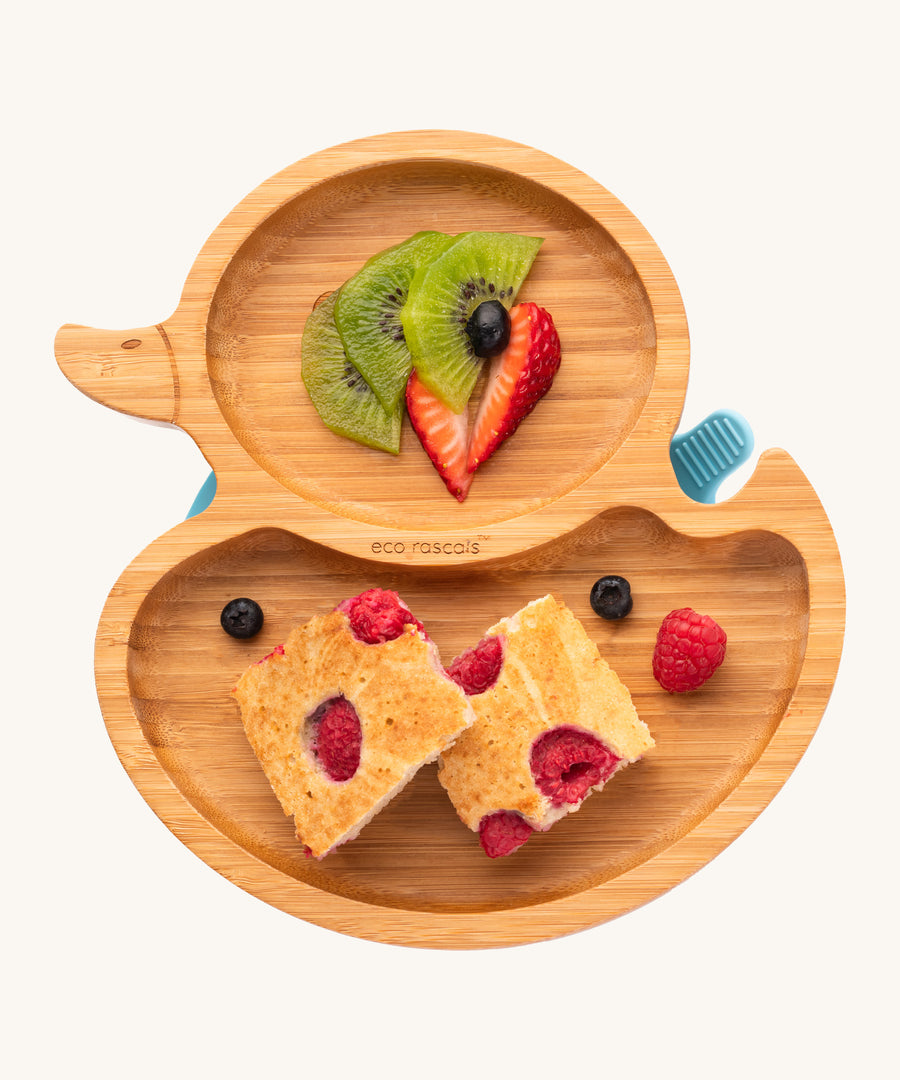 Bamboo duck-shaped weaning plate with fruit and cake.