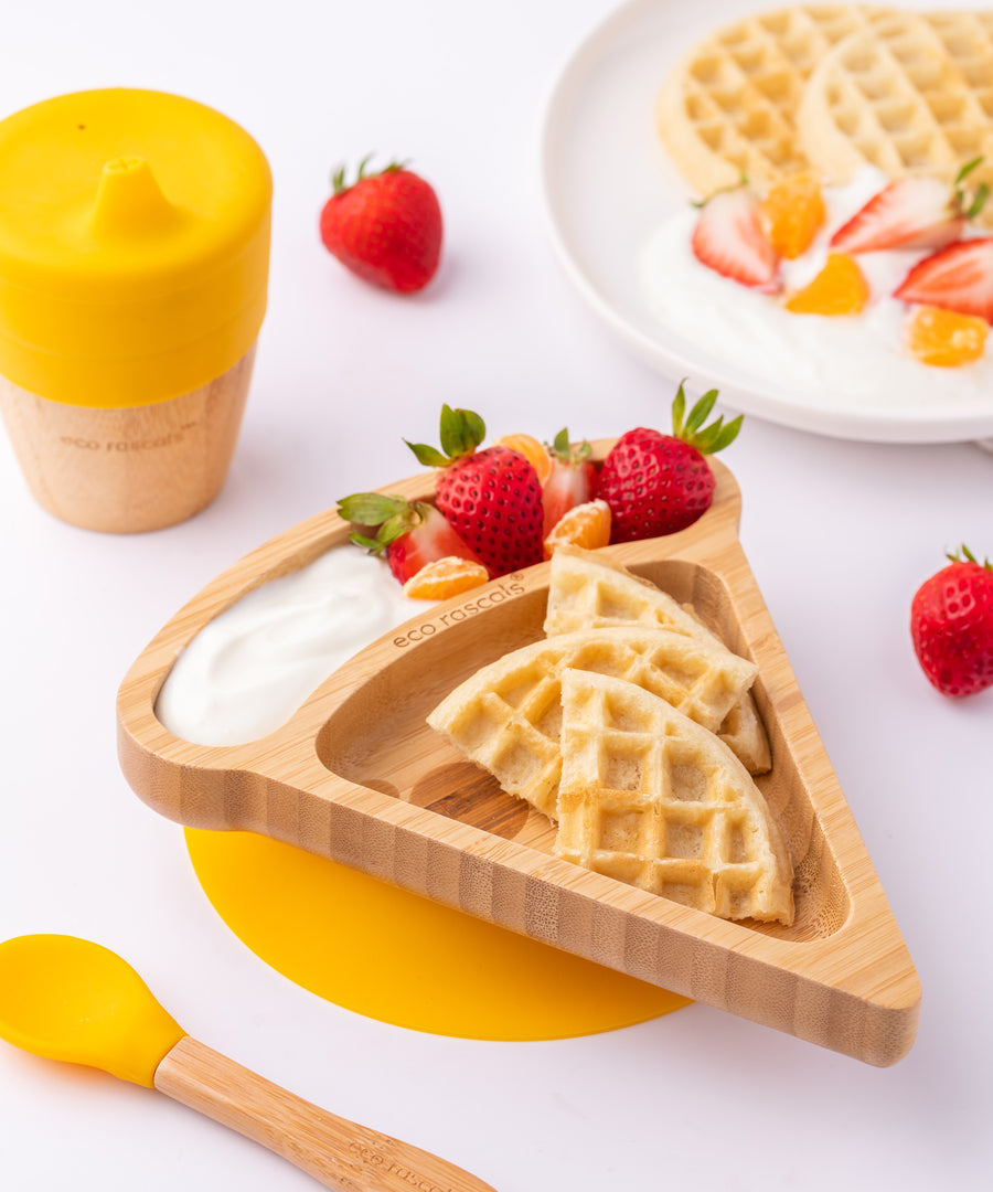 The Eco Rascals Pizza Bamboo Suction Plate with food inside, waffles are placed in the large triangle section and fruit and yoghurt are in the smaller curved section above. 