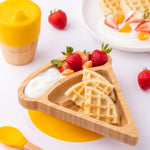 The Eco Rascals Pizza Bamboo Suction Plate with food inside, waffles are placed in the large triangle section and fruit and yoghurt are in the smaller curved section above. 