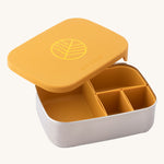 Eco Rascals Stainless Steel Lunch Box with a mustard yellow lid and pots on a plain background.