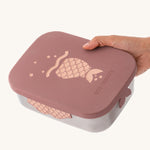 An adult's hand holding on to the rose pink mermaid design The rose pink mermaid design Eco Rascals Stainless Steel Character Lunch Box.