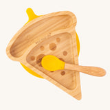 An overhead view of the Eco Rascals Pizza Bamboo Suction Plate and a matching yellow bamboo spoon on top on a plain background. The spoon is sold separately 