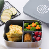 The Eco Rascals Stainless Steel Lunch Box with a silver grey silicone lid and pot inserts. The lid has been taken off and food can be seen in the lunchbox. 