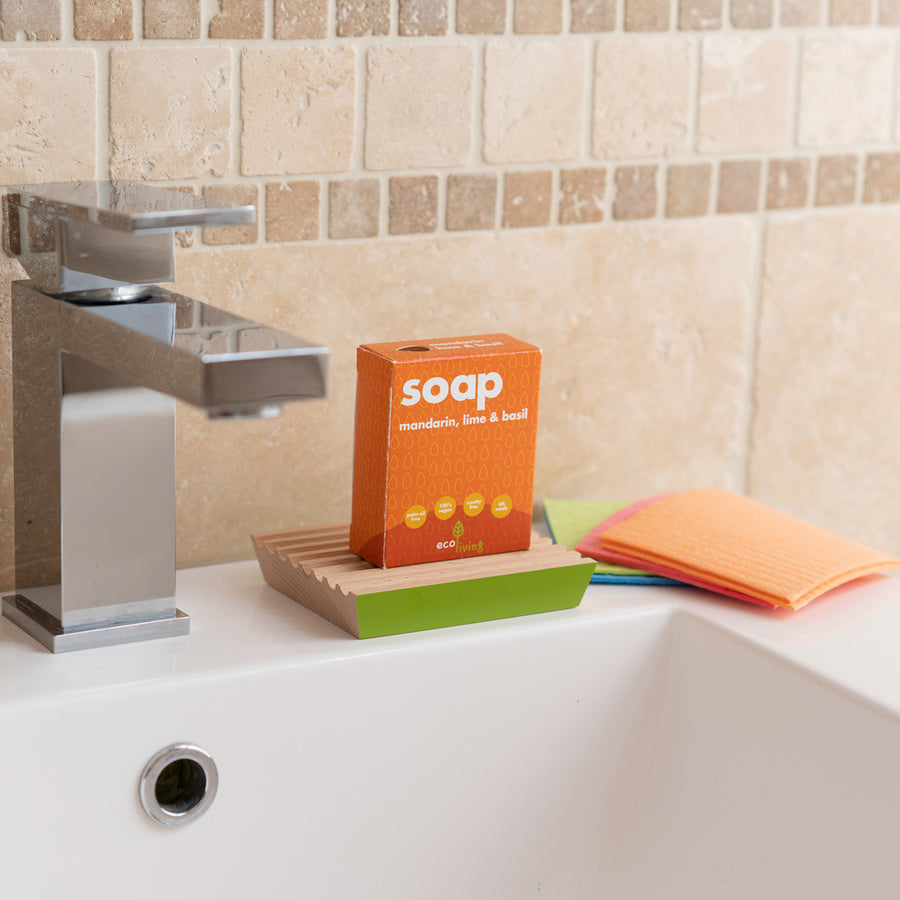 lime and basil soap bar on a white background next to its cardboard box