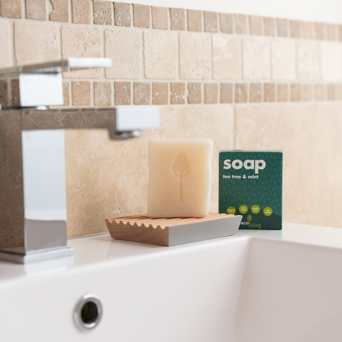 Ecoliving solid tea tree and mint soap bar on a wooden soap dish next to its cardboard box