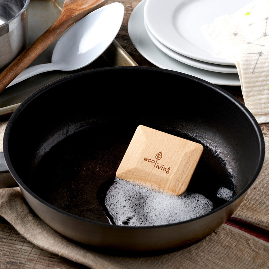 Ecoliving solid wooden pot scraper inside a black pot filled with bubbles