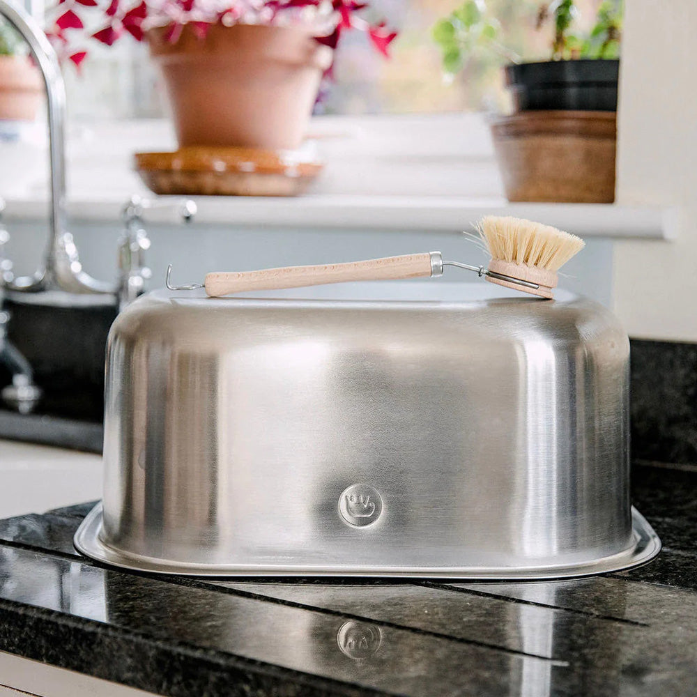 Elephant Box Eco-Friendly Stainless Steel Washing Up Bowl turned upside down with a wooden brush sat on the base