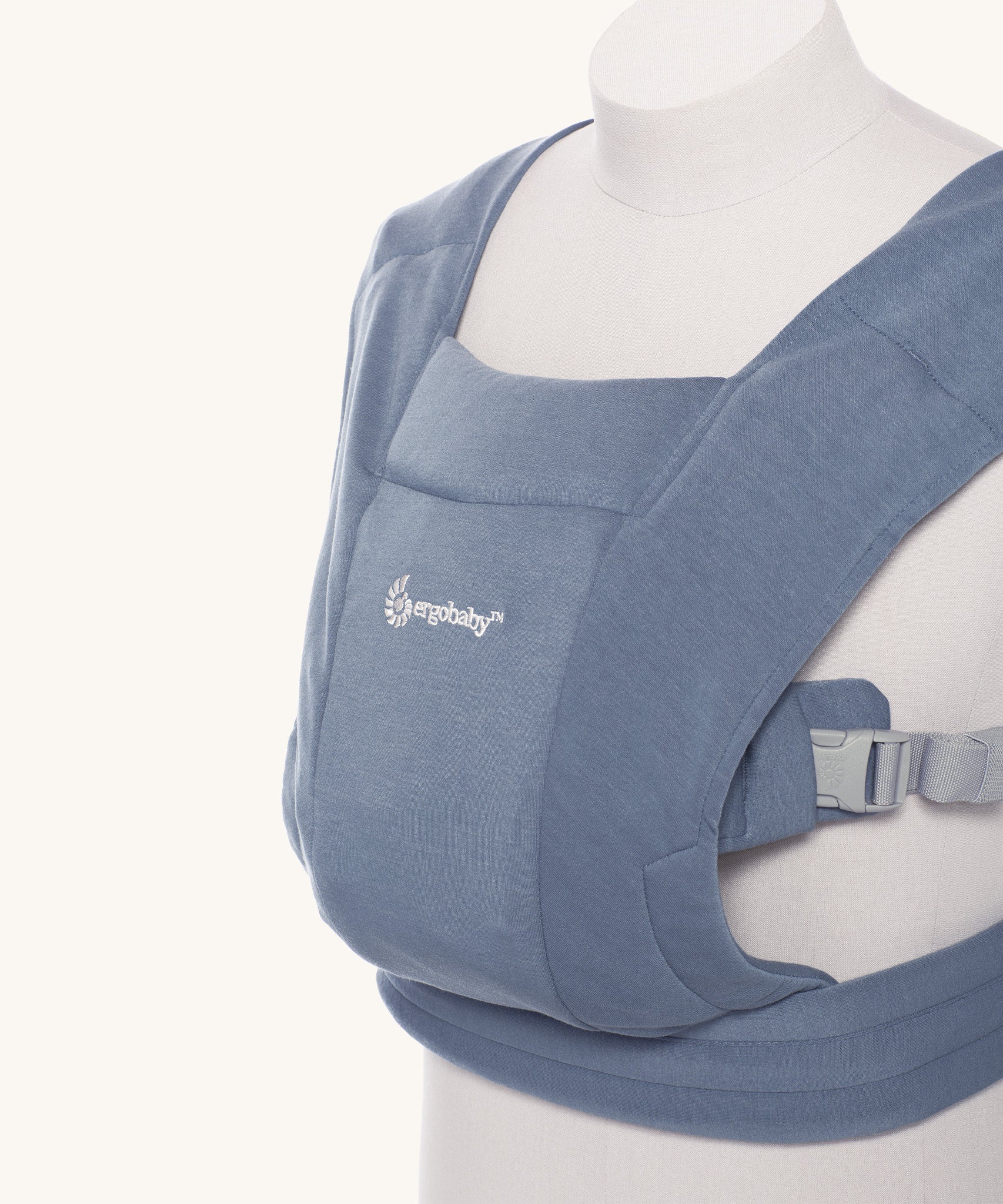 Close up of the Ergobaby Embrace Soft Knit Newborn Baby Carrier in Oxford Blue. Side view on a mannequin.